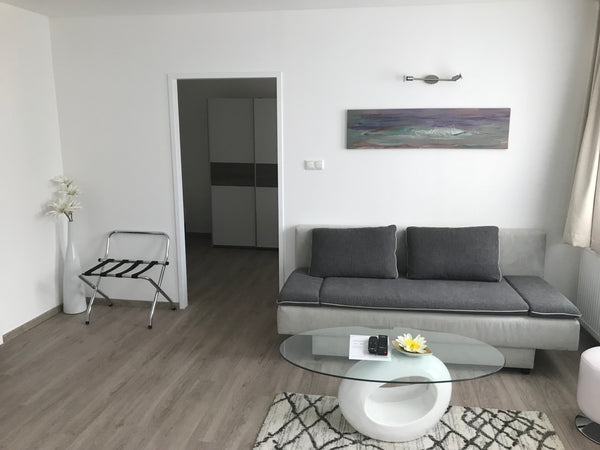 Wohnzimmer mit Schlafsofa und Kühlschrank, ein Schlafzimmer mit Doppel und Einze  Apartment/Studio Gerasdorf bei Wien Room in serviced apartment vacation rental 24234638