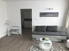 Wohnzimmer mit Schlafsofa und Kühlschrank, ein Schlafzimmer mit Doppel und Einze  Apartment/Studio Gerasdorf bei Wien Room in serviced apartment vacation rental 24234638