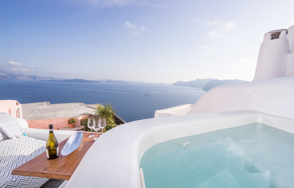 The sky changing colors. A glass of wine. Your private jacuzzi. The Aegean Sea,  Oia, Greece Canvas Suites | Earth Suite with Outdoor Jacuzzi Cycladic home vacation rental 5877166