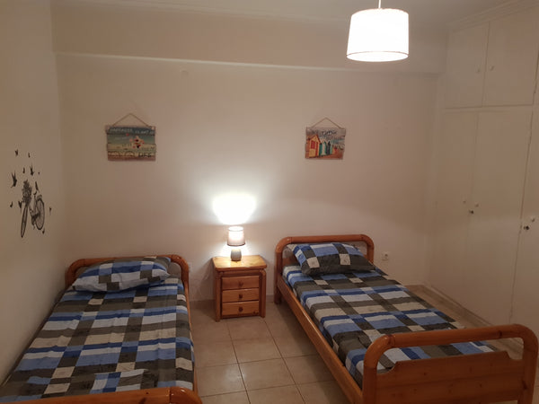 One room and a corridor with two single beds, two tables,three chairs and a tv s Marousi, Greece SMALL HOUSE NEAR THE CENTRE OF ATHENS Entire rental unit vacation rental 25528569